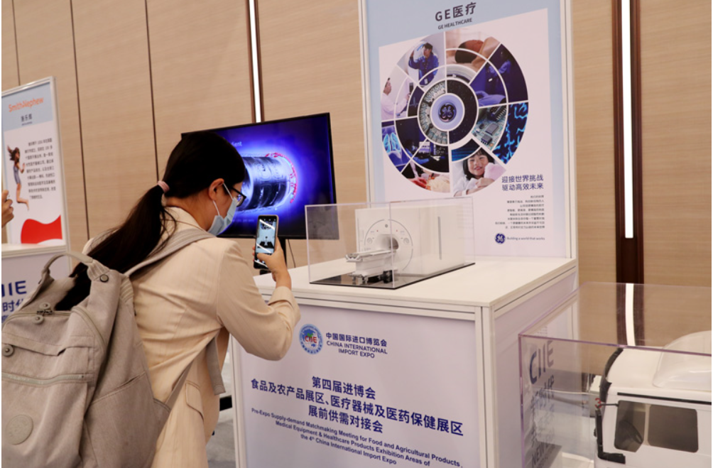 第四屆進(jìn)博會食品及農(nóng)產(chǎn)品展區(qū)、醫(yī)療器械及醫(yī)藥保健展區(qū)展前供需對接會的參會嘉賓用手機(jī)拍攝參展企業(yè)的展品模型
